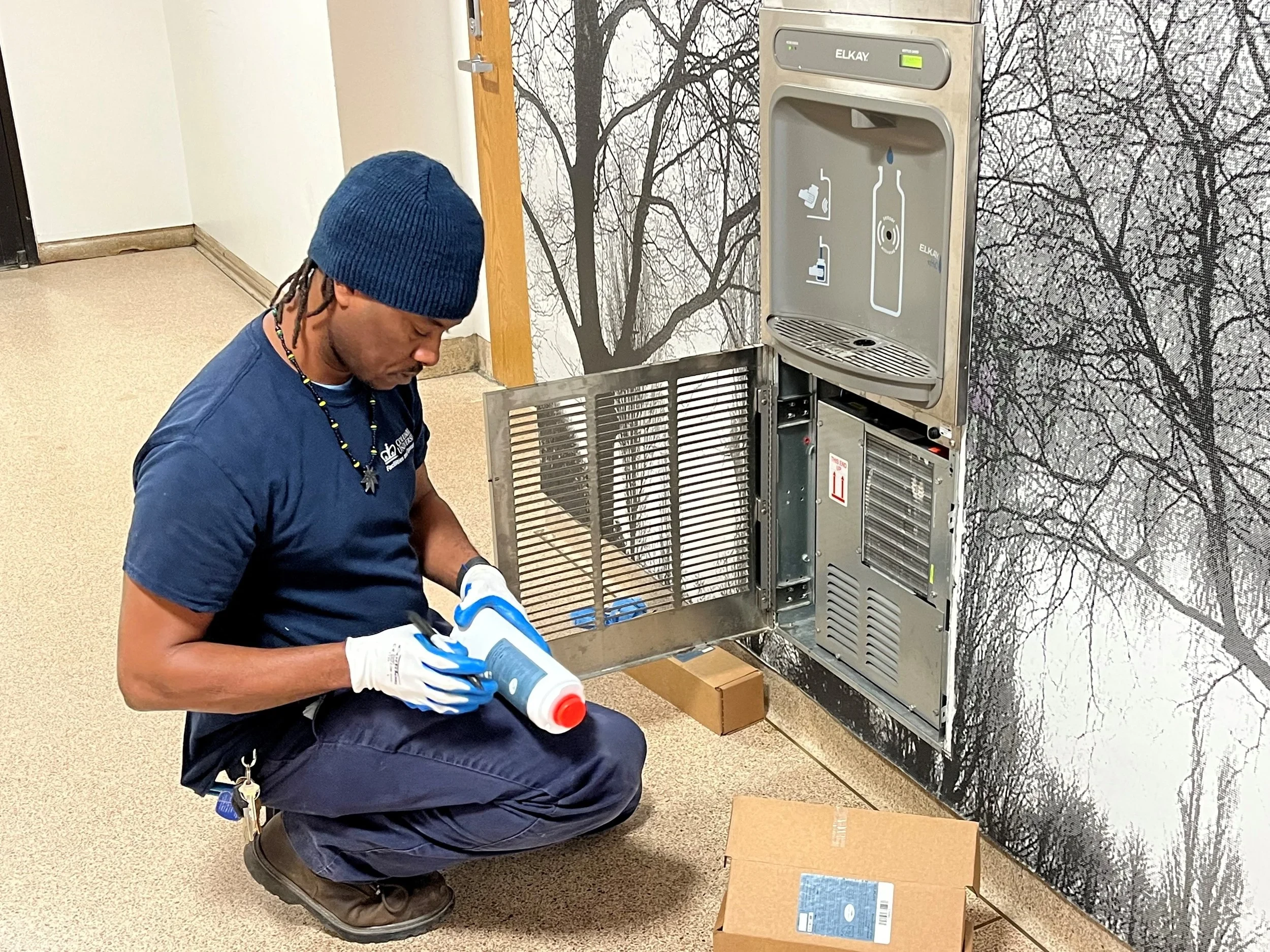 Technician servicing a commercial drinking fountain compressor