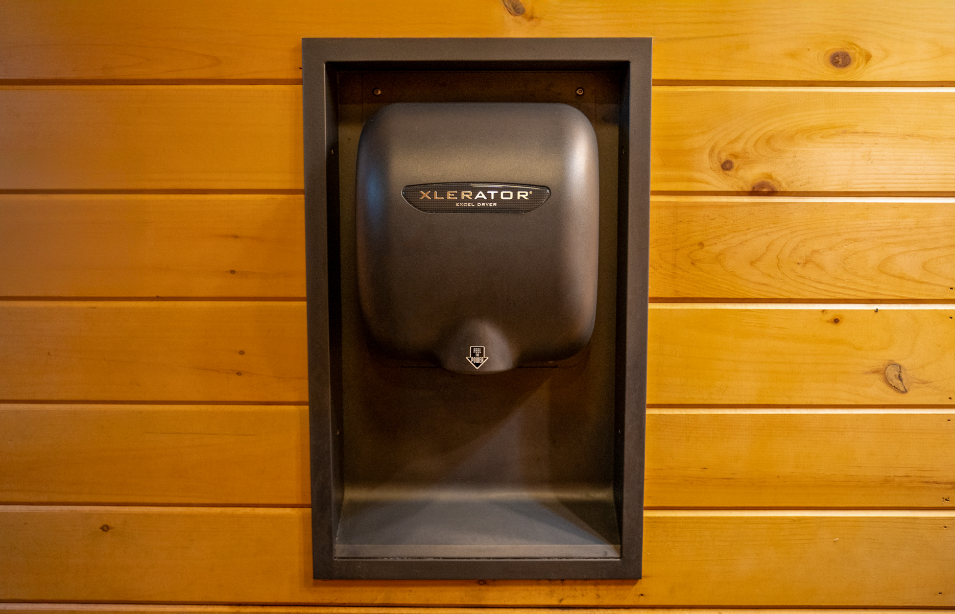 Excel XLERATOR hand dryer recessed in log cabin wood wall restroom